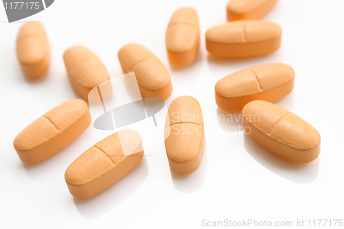 Image of orange pills over white