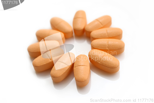 Image of orange pills over white