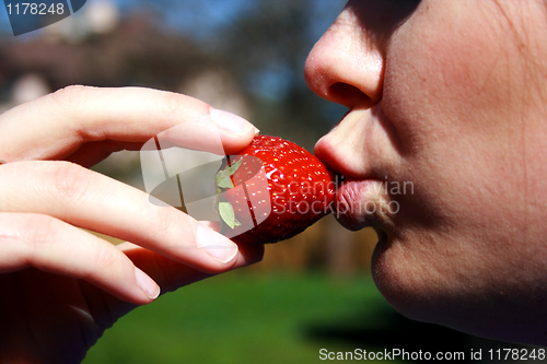 Image of face of the woman eating a strawberry