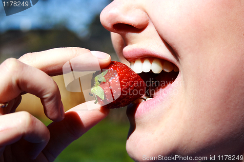 Image of face of the  woman eating a strawberry