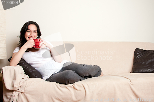 Image of Woman with drink on couch