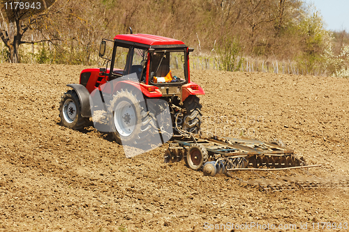 Image of Tractor with disk harrow and rake