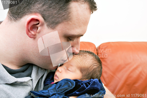 Image of Happy Father Kisses His Newborn Baby