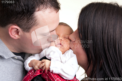 Image of Happy Parents Kiss Their Newborn Baby
