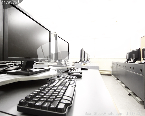 Image of workplace room with computers in row 