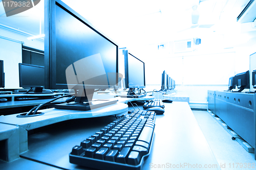 Image of workplace room with computers in row 