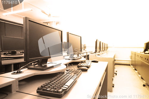 Image of workplace room with computers in row 