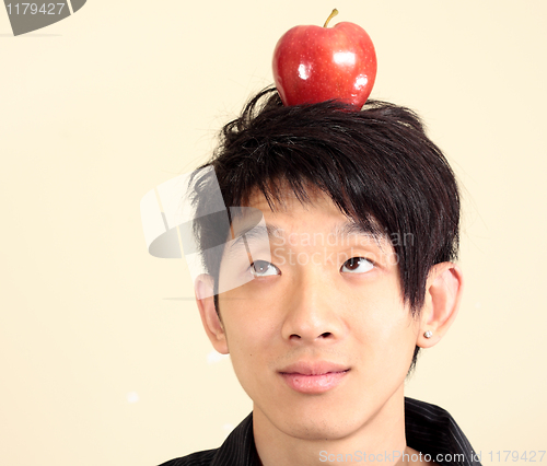 Image of young man with an apple on his head 