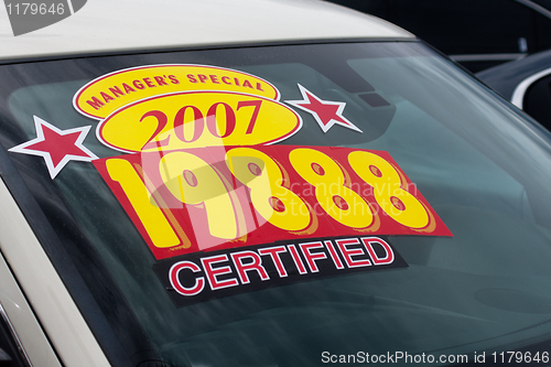 Image of price sticker on used car lot