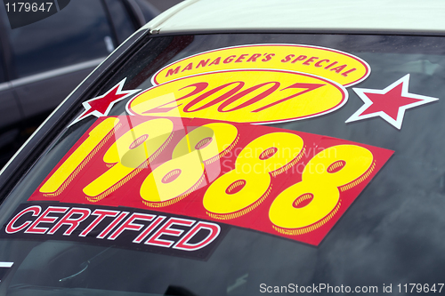 Image of price sticker on used car lot