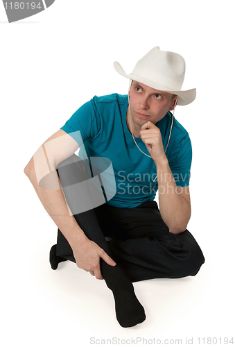 Image of man in a cowboy hat sitting in the lotus position