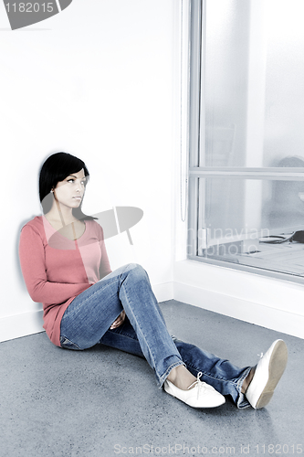 Image of Depressed woman sitting on the floor