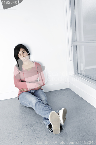 Image of Depressed woman sitting on floor