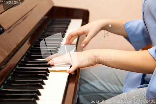 Image of Hands of a young girl playing the piano