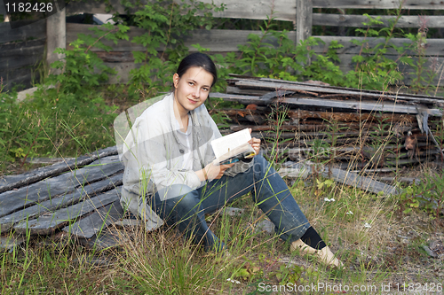 Image of Girl reading a book at the cottage
