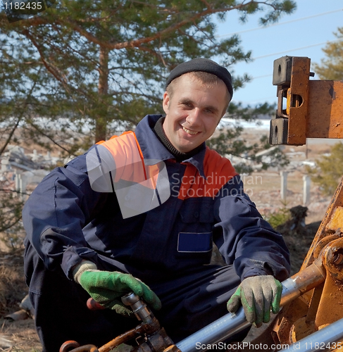 Image of Machinist excavator with a wrench in his hand