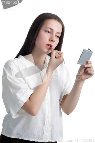 Image of A young girl with her hair applying lipstick