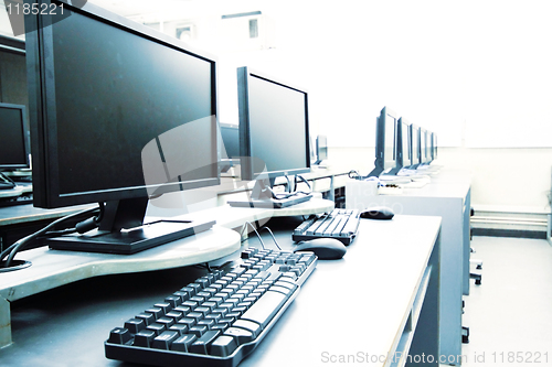 Image of workplace room with computers in row 