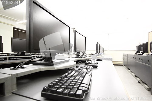 Image of workplace room with computers in row 