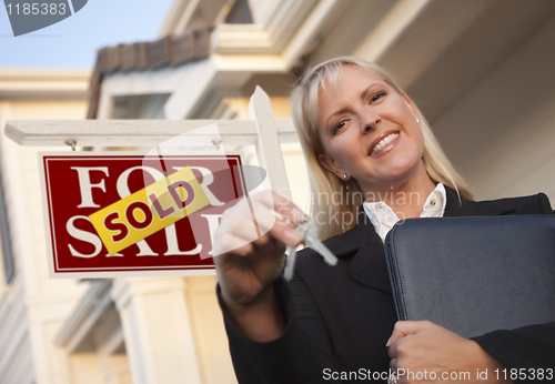 Image of Real Estate Agent with Keys in Front of Sold Sign and House