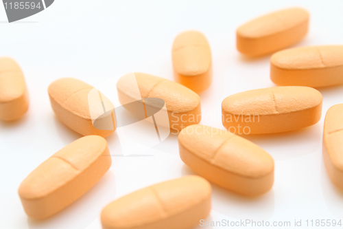 Image of orange pills over white 