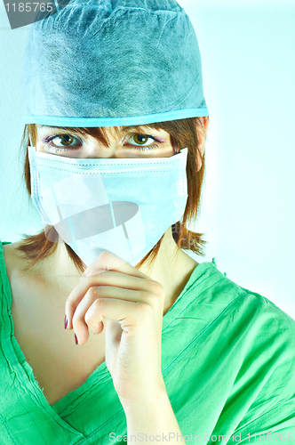 Image of Woman surgeon holding her chin and has a serious look on her fac