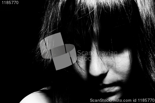 Image of A sad girl looking down with her eyes unseen in black and white