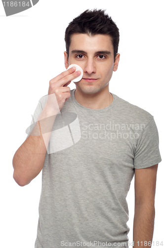 Image of Young man cleaning face