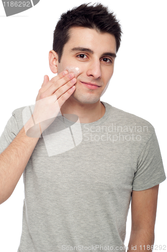 Image of Young man applying cream lotion