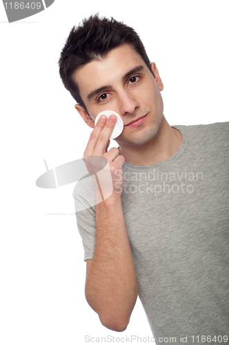 Image of Young man cleaning face