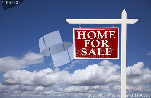 Image of Red Home For Sale Real Estate Sign Over Clouds and Sky