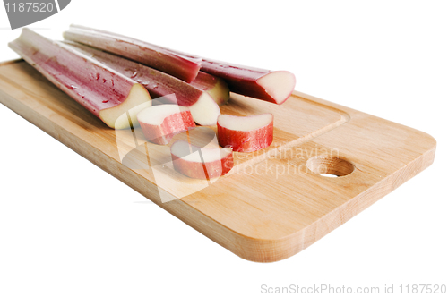 Image of Rhubarb on a kitchen board, it is isolated on white