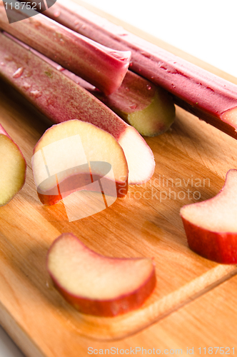 Image of Rhubarb on a kitchen board, it is isolated on white