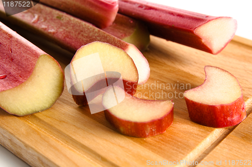 Image of Rhubarb on a kitchen board, it is isolated on white