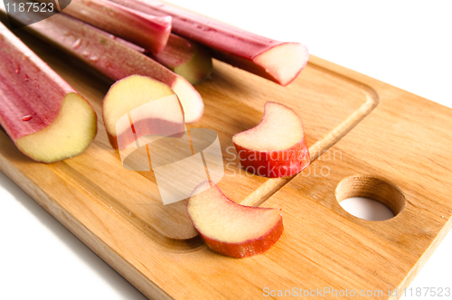 Image of Rhubarb on a kitchen board, it is isolated on white