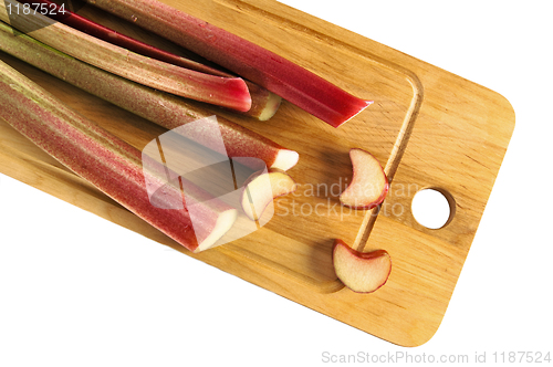 Image of Rhubarb on a kitchen board, it is isolated on white