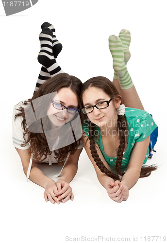 Image of two sisters lying on a white floor