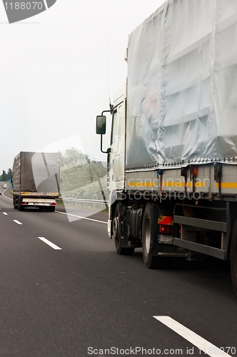 Image of Trucks traveling on highway delivering goods