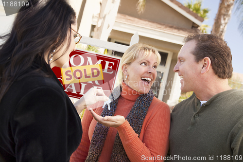 Image of Hispanic Female Real Estate Agent Handing Keys to Excited Couple