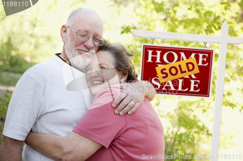 Image of Senior Couple in Front of Sold Real Estate Sign