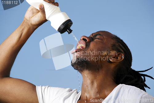 Image of Young athletic man taking a break during a challenging jogging o