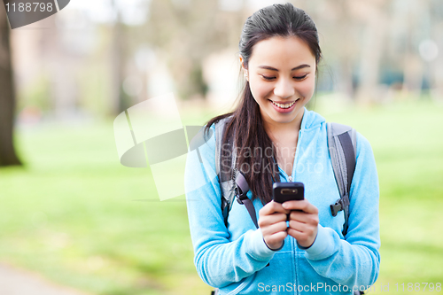 Image of Asian student texting on the phone