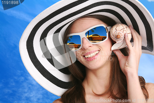 Image of woman listens seashell