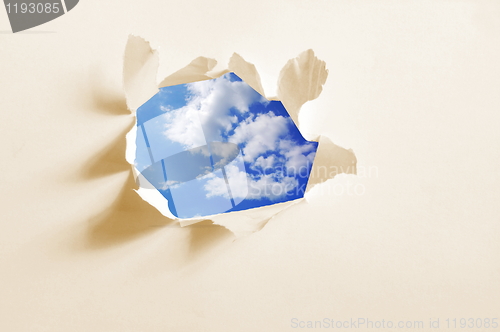 Image of cloudy sky behind paper hole