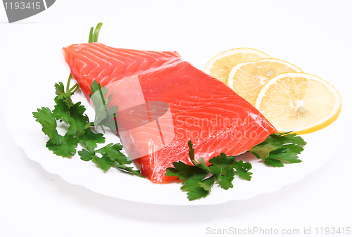 Image of Salmon steak with lemon slices and parsley on white plate