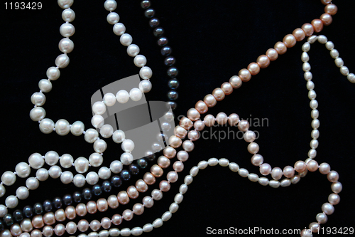 Image of White, black and pink pearls on the black silk 