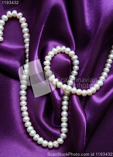 Image of White pearls on a lilac silk background 