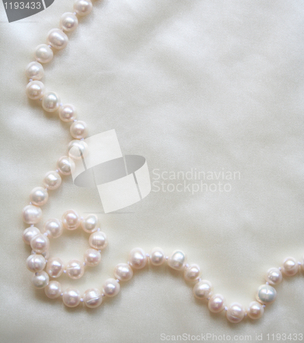 Image of White pearls on the white silk 