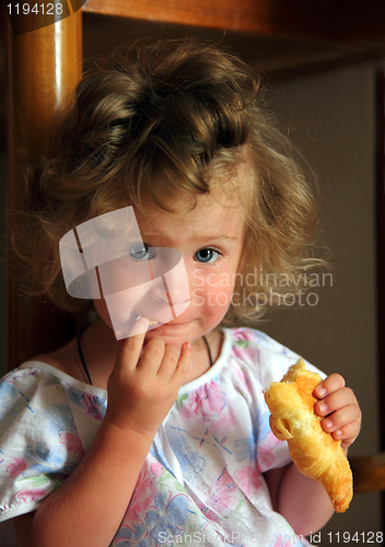 Image of little girl eating croissant