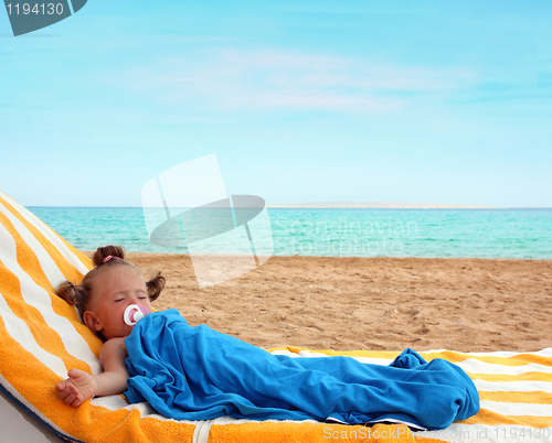 Image of little girl sleeping on beach